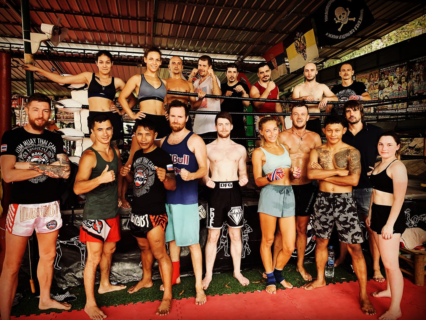 Fighters and trainers of the Tom Muay Thai Gym on Koh Samui stand at a boxing ring