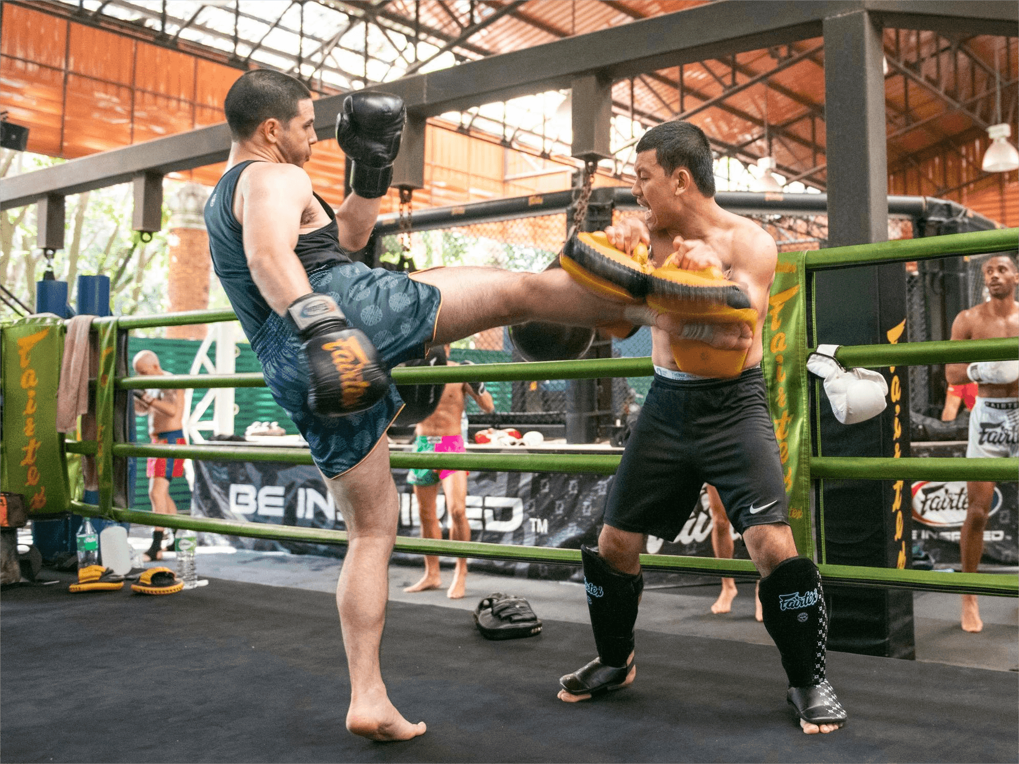 Coach and fighter do pad work in Muay Thai training at the Fairtex Training Center in Pattaya.