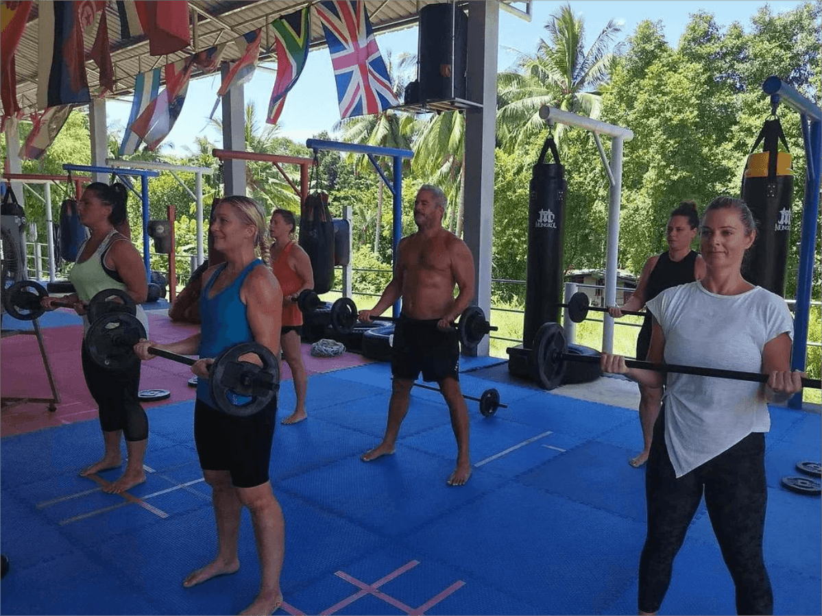 Athletes train with barbells in the Chinnarach Muay Thai Gym in Koh Samui