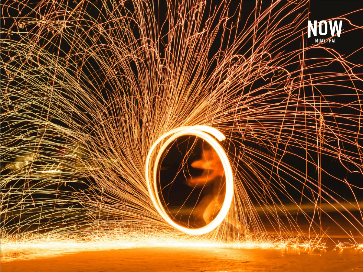 Fire artists with a lively spark show on the beach in Thailand